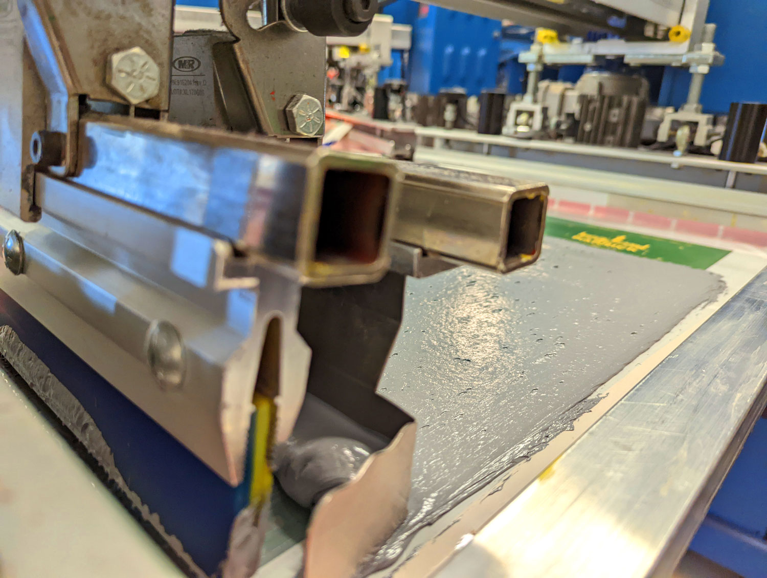 Detail shot of a Screen Printing press rolling ink onto a design